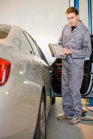 Mechanic examining car in garageの写真素材