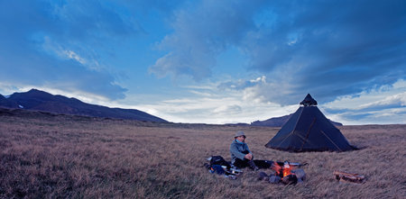 Man camping in grassy field