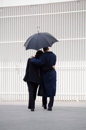 Couple walking under umbrellaの写真素材