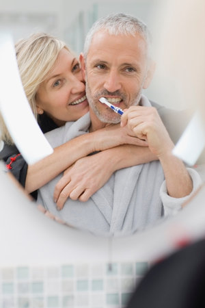 Man brushing his teeth with wifeの写真素材