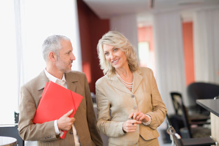 Business people talking in lobby areaの写真素材