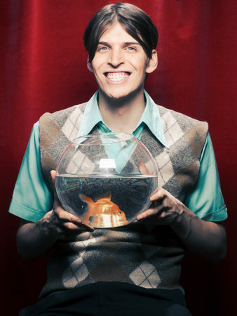 Smiling man holding fishbowlの写真素材