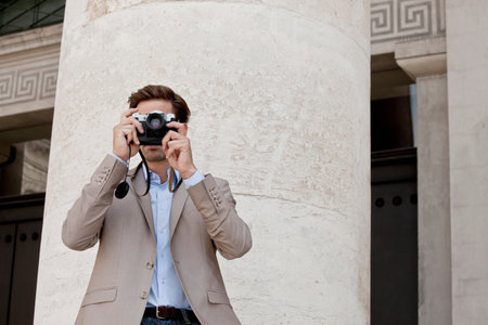 Man taking pictures by columned building