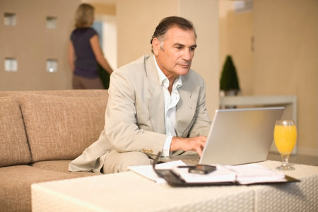 Businessman working on couchの写真素材