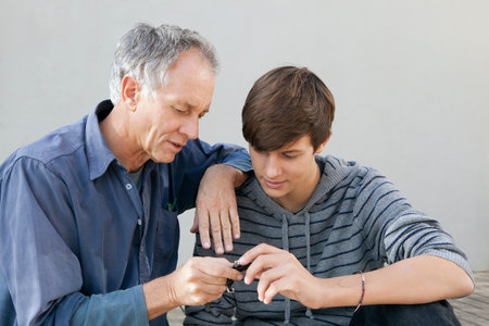 Father and son examining tool togetherの写真素材