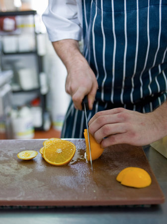 Chef slicing in restaurant kitchenの写真素材
