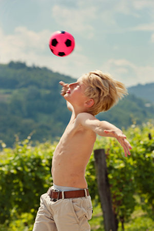 Boy playing with soccer ball outdoorsの写真素材
