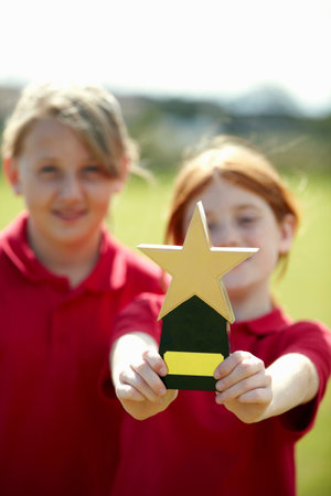Girl cheering with trophy outdoorsの写真素材