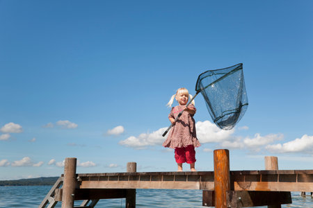 Girl fishing with net in lakeの写真素材