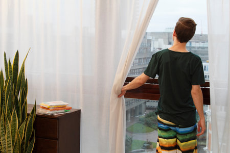 Man opening curtainsの写真素材