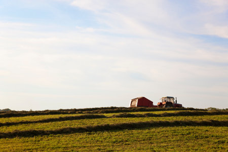Tractor harvesting crops in fieldの写真素材