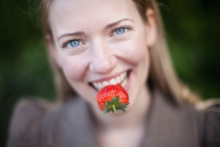 Close up of strawberry in woman?s mouthの写真素材