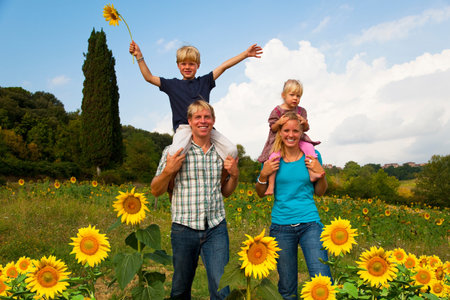 Family walking in field of flowersの写真素材