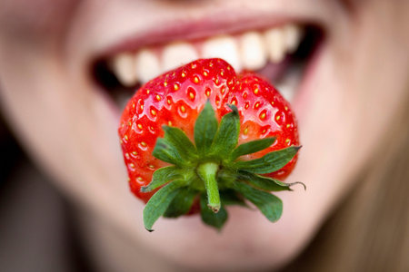Close up of strawberry in woman?s mouthの写真素材