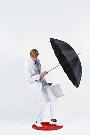A businessman holding an umbrellaの写真素材
