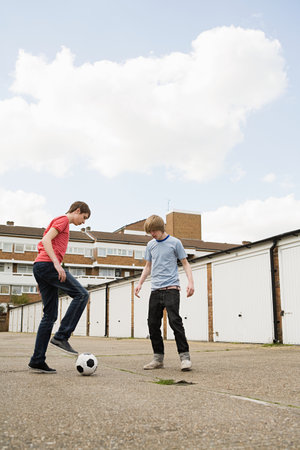 Teenage boys playing footballの写真素材