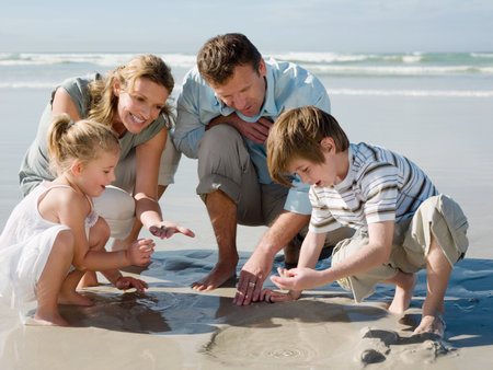 Family looking in sandの写真素材