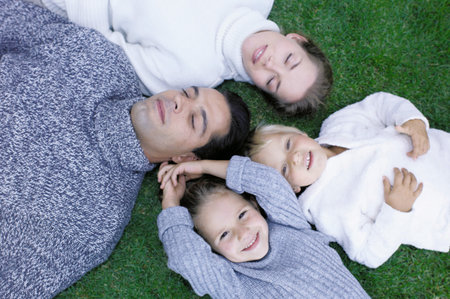 Family lying on the grassの写真素材