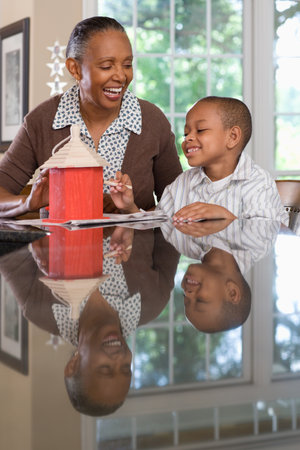 A grandmother and grandson painting a birdhouseの写真素材