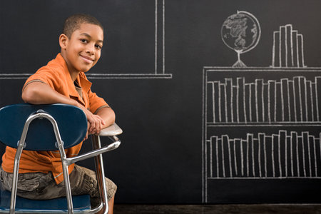 Portrait of a boy sat at a deskの写真素材