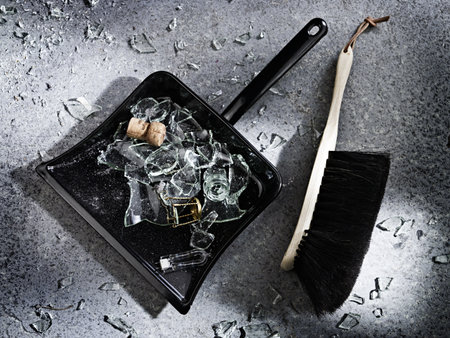 Broken glass and a dustpan and brush