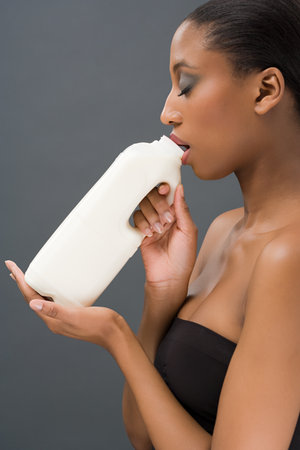 Woman drinking a bottle of milkの写真素材
