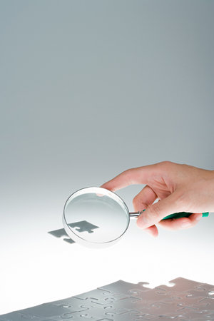 Person magnifying jigsaw pieceの写真素材