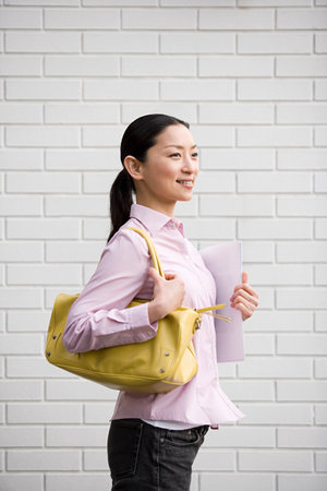 Smiling woman holding a handbagの写真素材