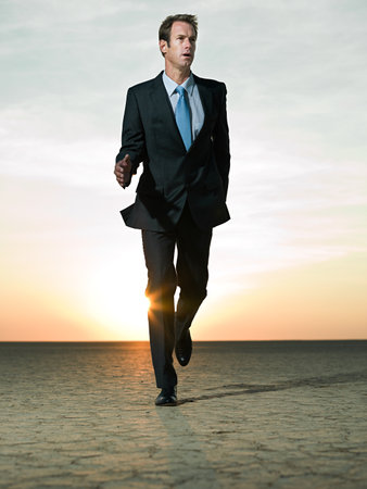 Businessman running in the desertの写真素材