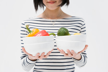Woman holding bowls of vegetablesの写真素材