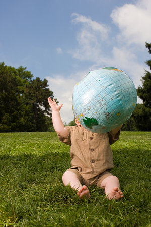 Baby in park with inflatable globeの写真素材
