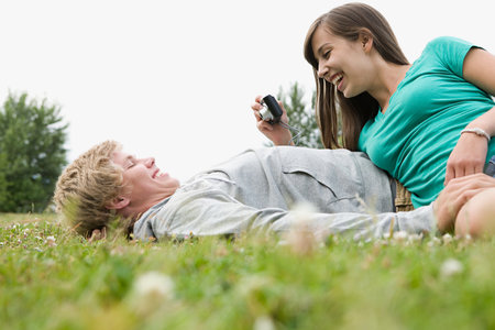 Teenage couple with digital cameraの写真素材