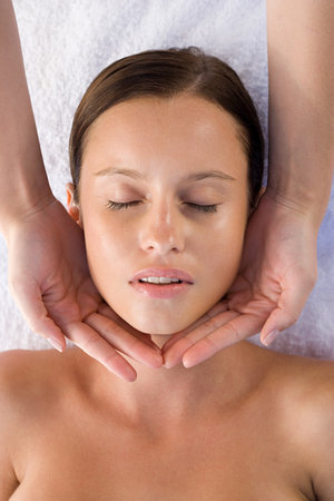 Young woman receiving facial massageの写真素材