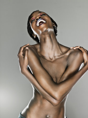 Happy young woman with arms over chestの写真素材