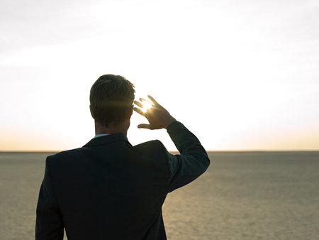 Businessman looking into the sunの写真素材