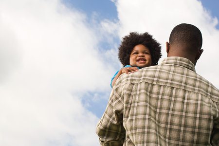 Baby being carried by fatherの写真素材