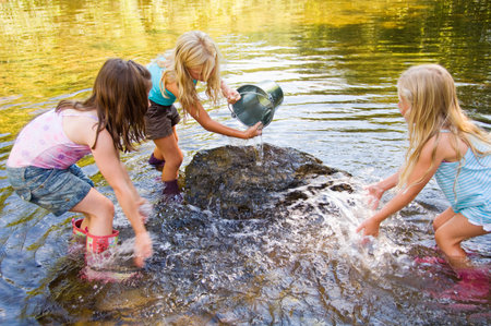 Girls in river with bucketの写真素材