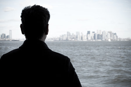 Man looking over river to manhattanの写真素材