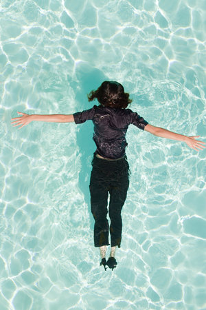 Woman face down in swimming poolの写真素材