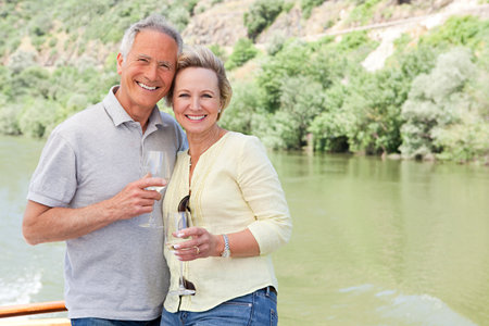 Senior couple with glasses of wine on a boat holidayの写真素材
