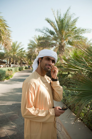 Middle Eastern man listening to music on mobile phoneの写真素材