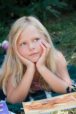 Girls lying on front with bookの写真素材