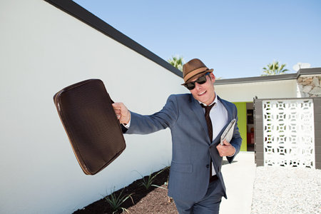 Confident businessman with briefcase and trilbyの写真素材