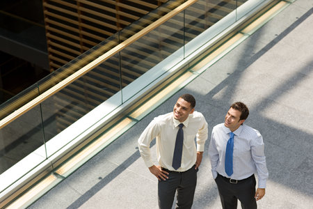 Businessmen on office walkwayの写真素材