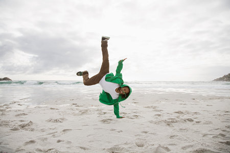 Young man doing cartwheels on beach