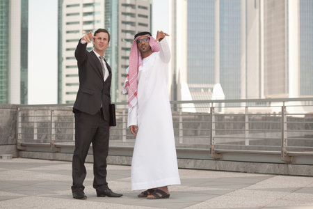 Western and middle eastern businessmen pointingの写真素材