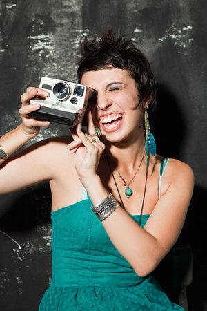 Woman wearing green dress at party taking photograph