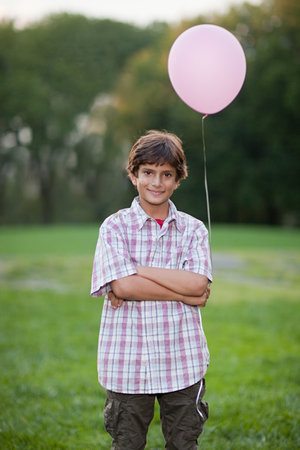 Boy at birthday party holding pink balloonの写真素材