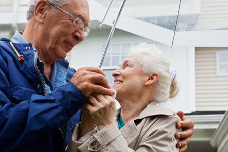 Senior couple holding umbrella outsideの写真素材