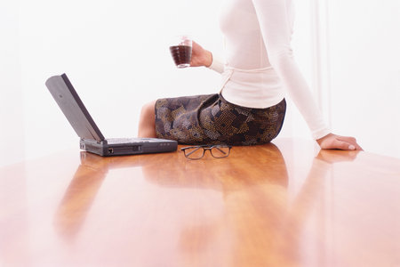 Woman on desk with laptopの写真素材